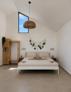 Double bed beneath leaf wall decor and a woven pendant light.