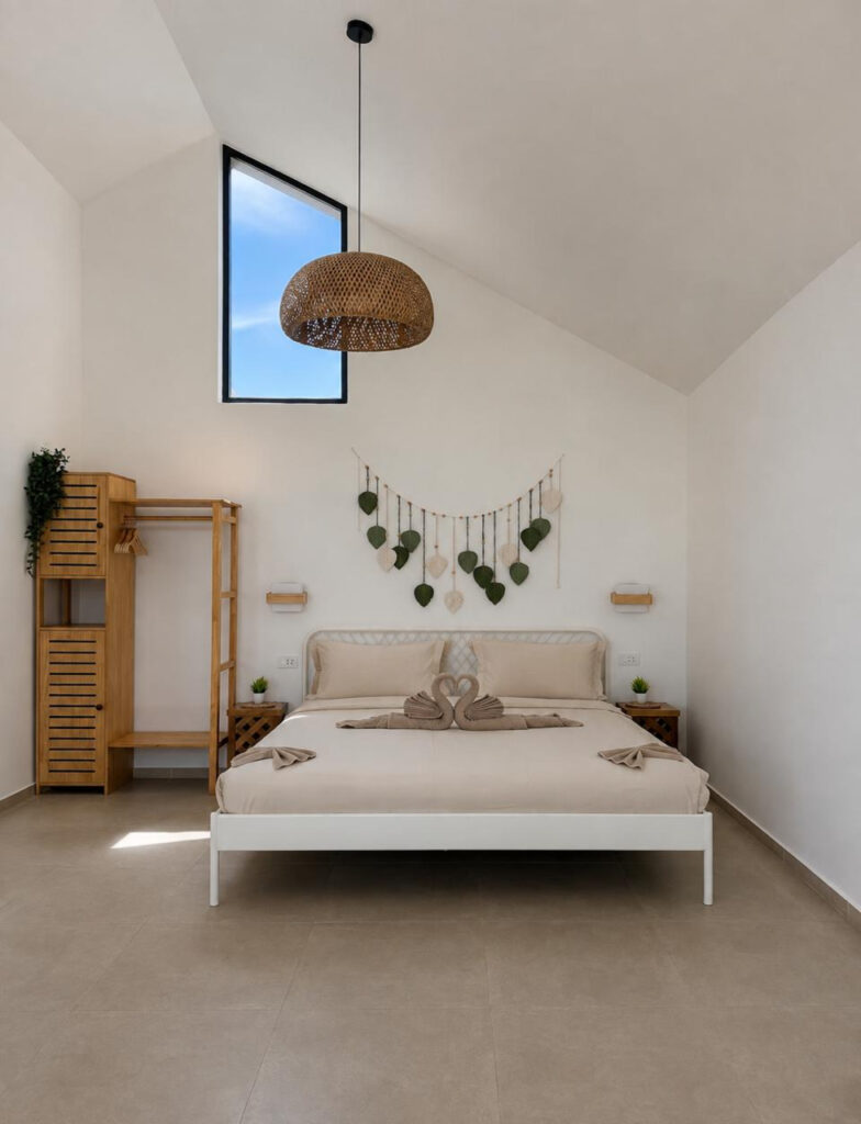 Double bed beneath leaf wall decor and a woven pendant light.