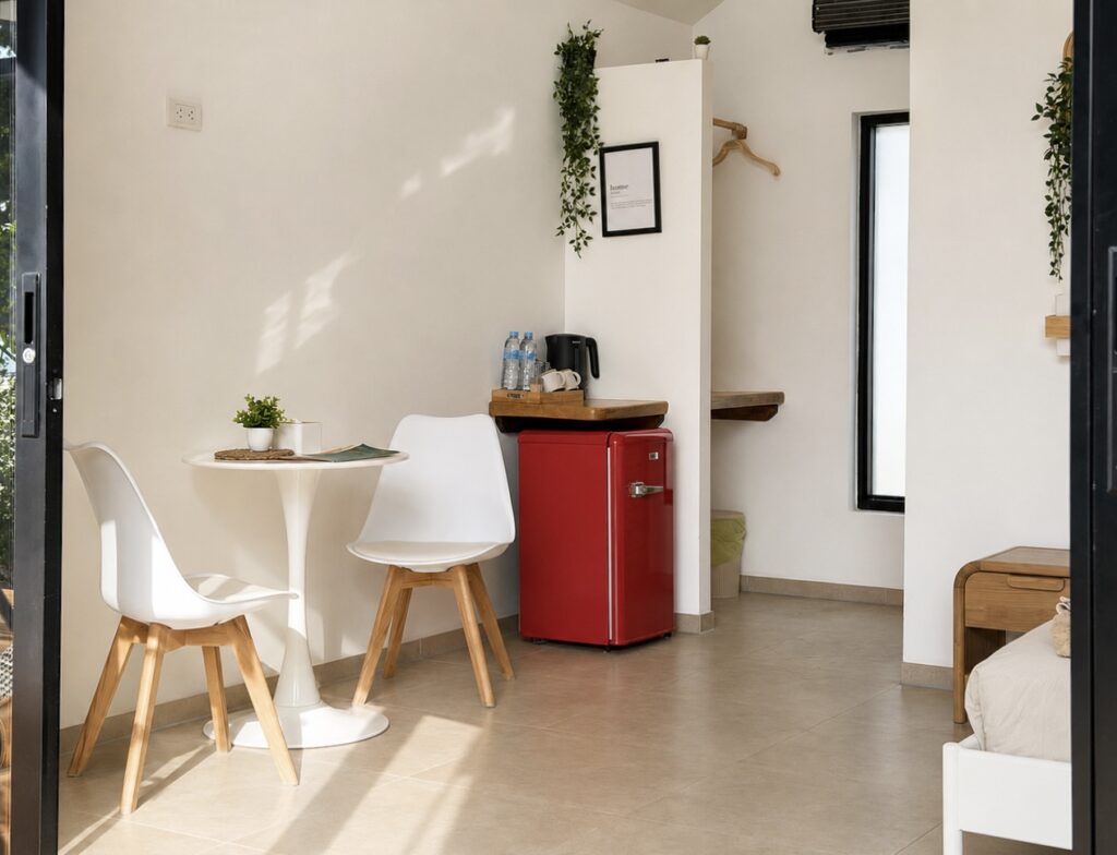 White dining table and red mini refrigerator beside the kettle shelf.