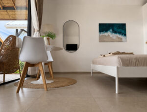 Wide bedroom view with a dining table beside the glass front and terrace seating.