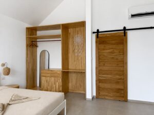 Bedroom view with a double bed, wooden wardrobe and sliding door.