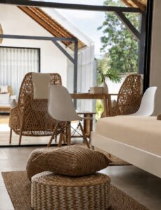 Dining corner and woven pouffes beside the glass doors to the terrace.