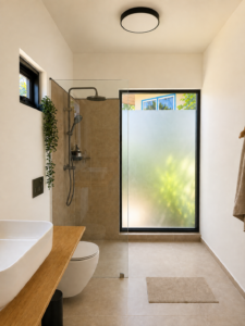 Bathroom with a countertop basin, shower and frosted-glass door.
