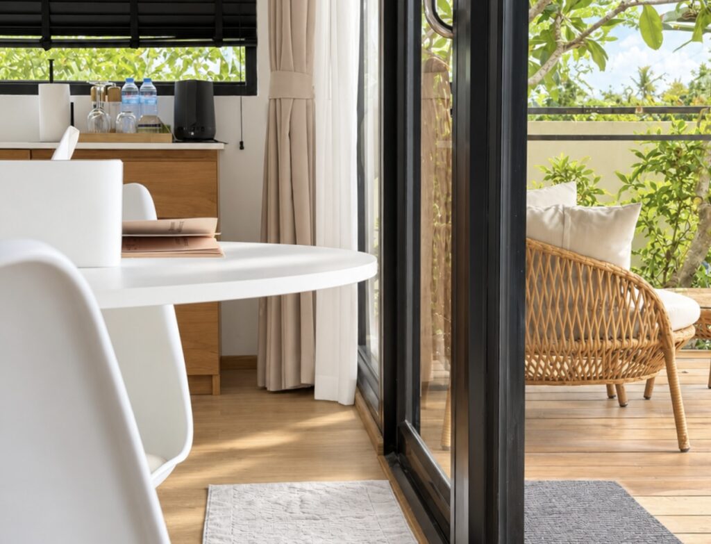 White dining table beside the open glass door to the terrace.