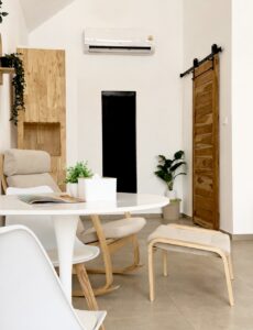 Dining table and armchair near the wooden sliding door and indoor plants.