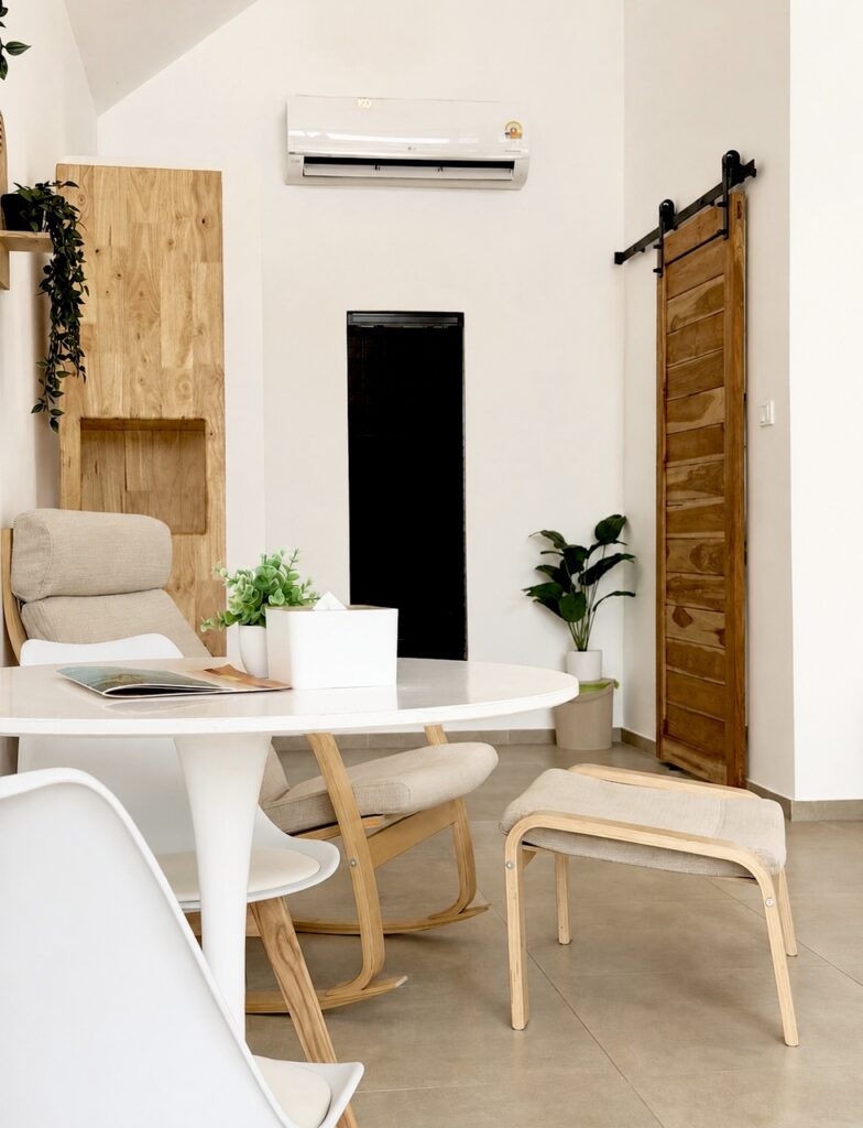 Dining table and armchair near the wooden sliding door and indoor plants.