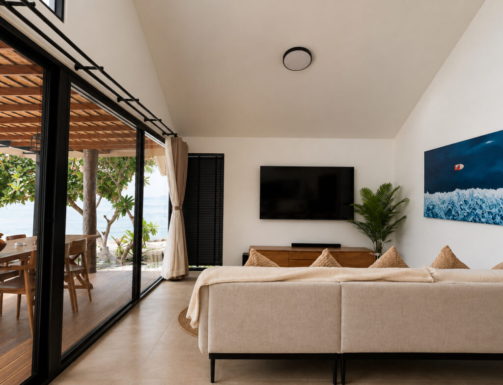 Living room with a sofa, television and glass doors to the covered terrace.