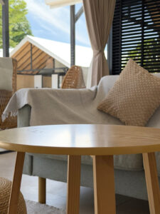 Sofa cushions and a round coffee table beside the glass doors and terrace.