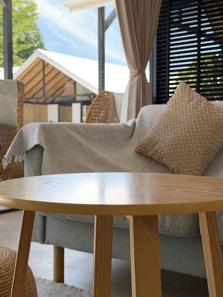 Sofa cushions and a round coffee table beside the glass doors and terrace.