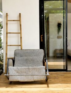 Front view of a woven rocking chair on the wooden deck.