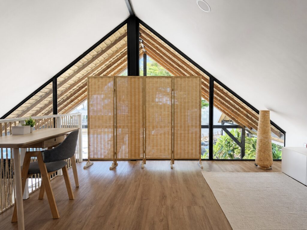 Upper-level table and woven screens beneath the glazed gable.