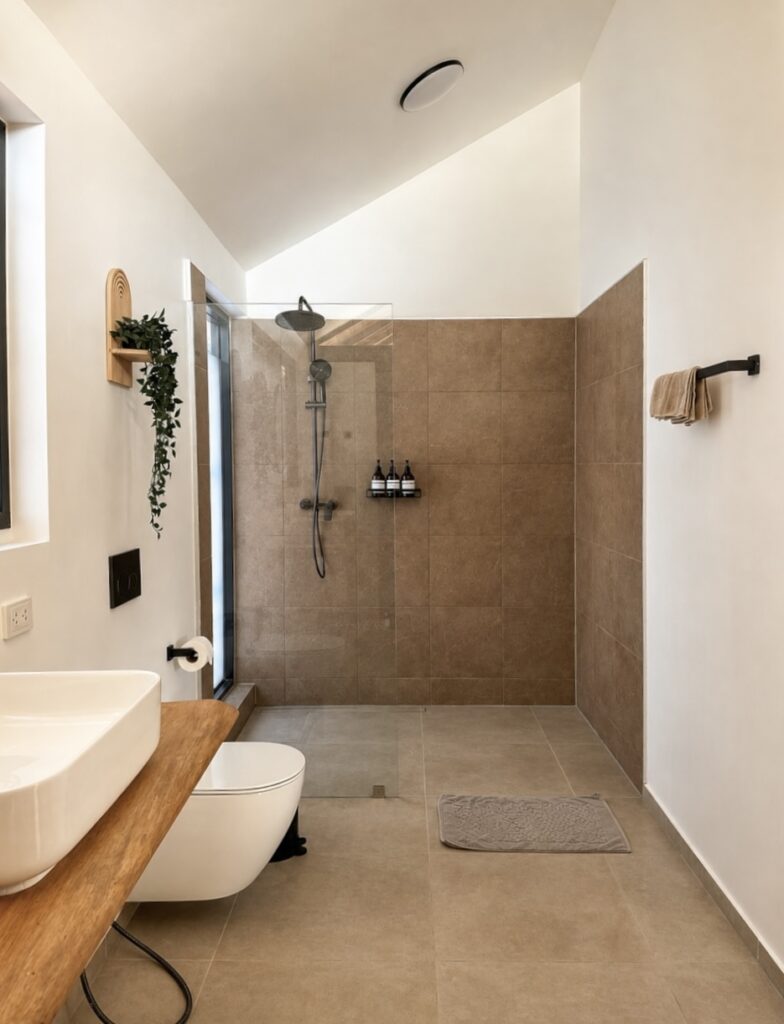 Bathroom with a countertop basin, toilet and walk-in shower.