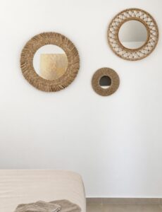 Three round woven-framed mirrors above the bed.