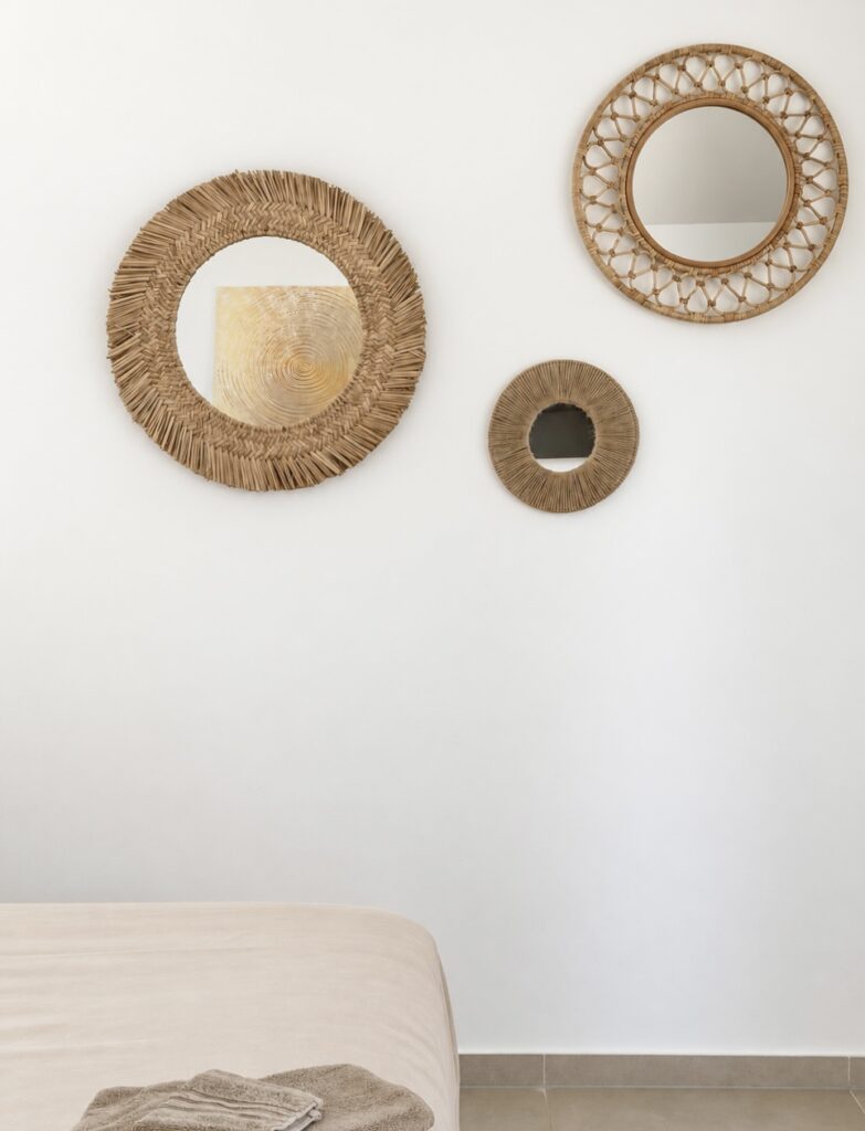 Three round woven-framed mirrors above the bed.