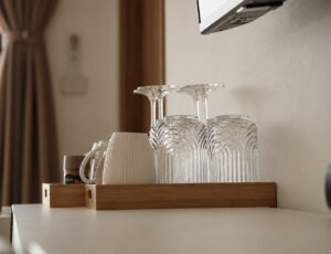 Cups, wine glasses and tumblers on a wooden tray.