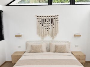 Double bed with textured cushions and wooden bedside tables.