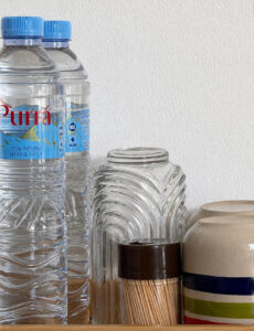 Bottled drinking water, glasses and cups on the refreshment tray.