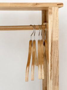 Wooden clothes hangers on the wardrobe rail.