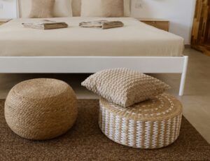 Woven pouffes and cushions at the foot of the bed.
