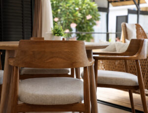 Wooden dining chairs beside doors opening to the furnished terrace.
