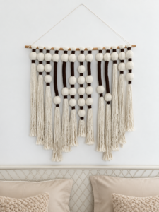 Close view of the macrame wall hanging above the bed pillows.